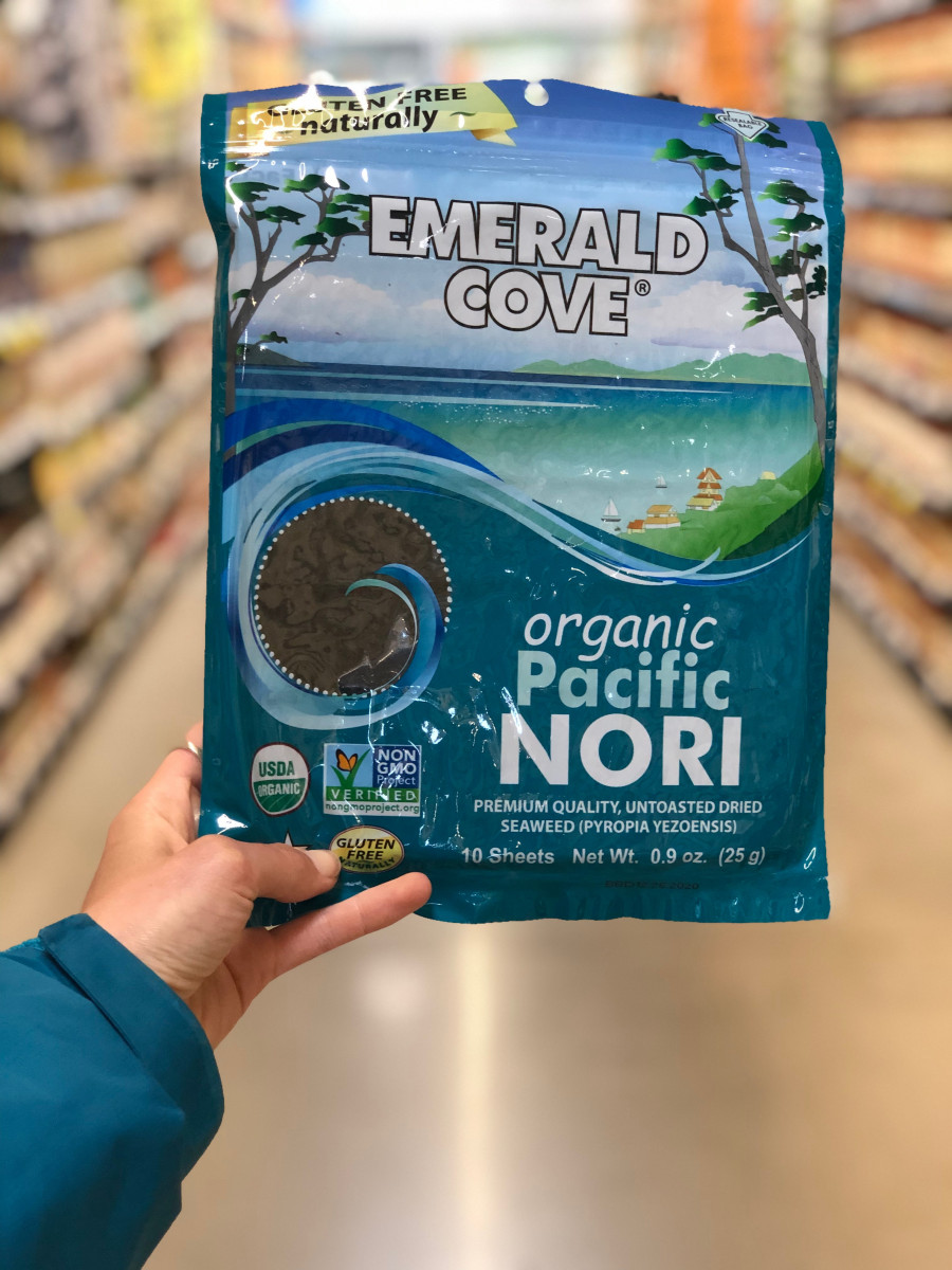 hand holding a package of nori in a supermarket aisle